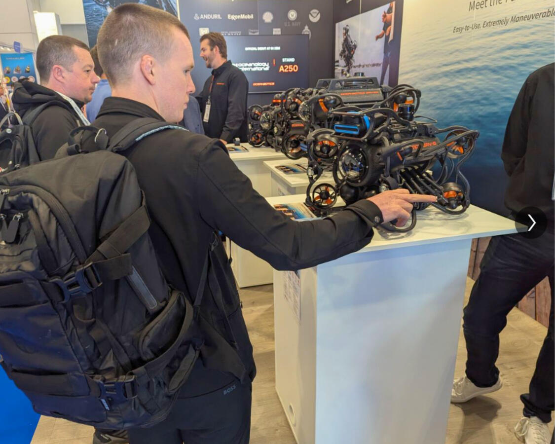 Trade Show Booth Design — Oceanbotics Inc Attendee interacting with underwater ROV display at Oceanbotics trade show booth designed by Sea Ranch Studio