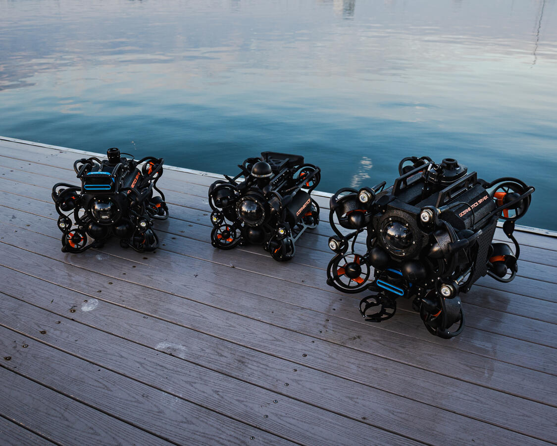 Product Display Styling for Corporate Trade Show Three SRV-8 ROV units staged on a dock at sunset for Oceanbotics trade show marketing photography