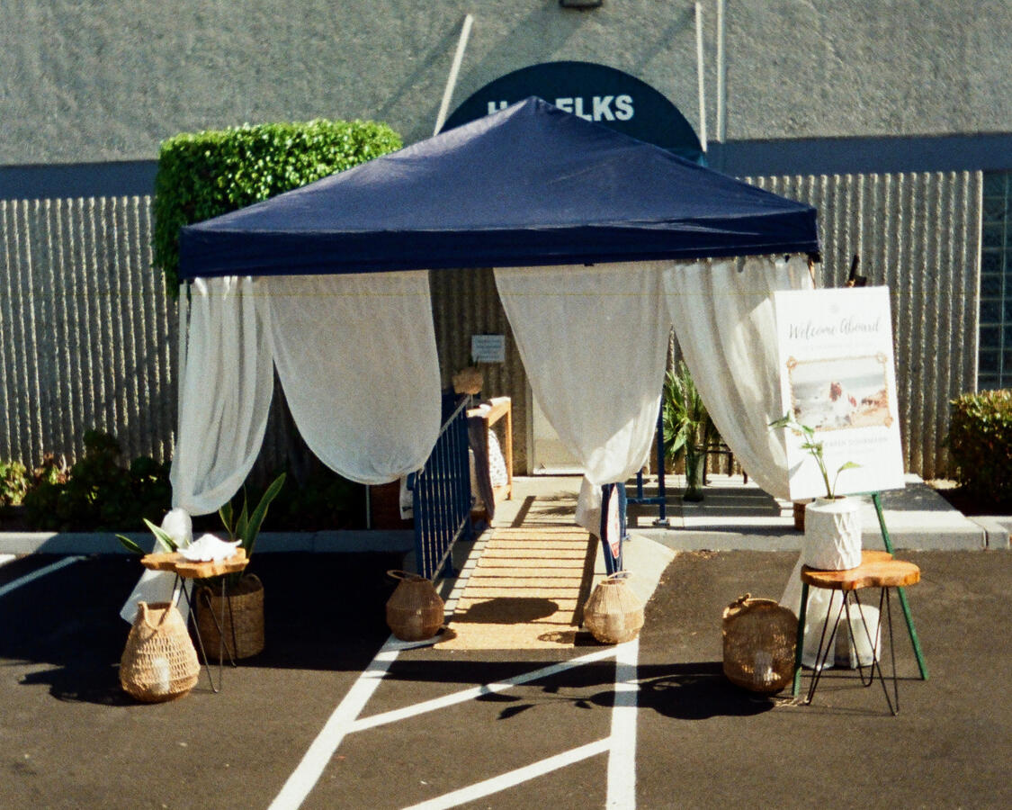 Celebration of Life Entrance Design — Nautical Theme Draped white tent entrance with coastal decor for nautical-themed celebration of life, Orange County