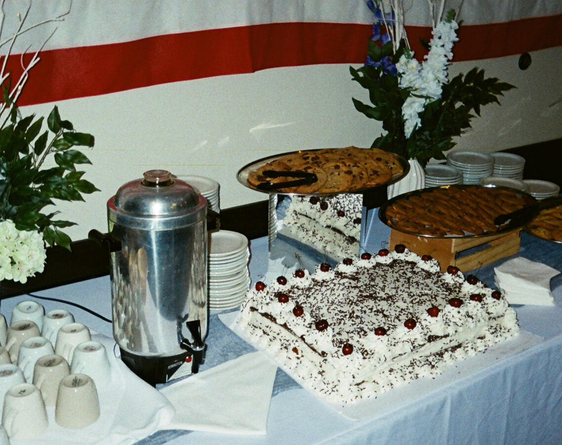 Celebration of Life Dessert Table Setup Dessert table with cake and floral arrangements for celebration of life event, Orange County event planning