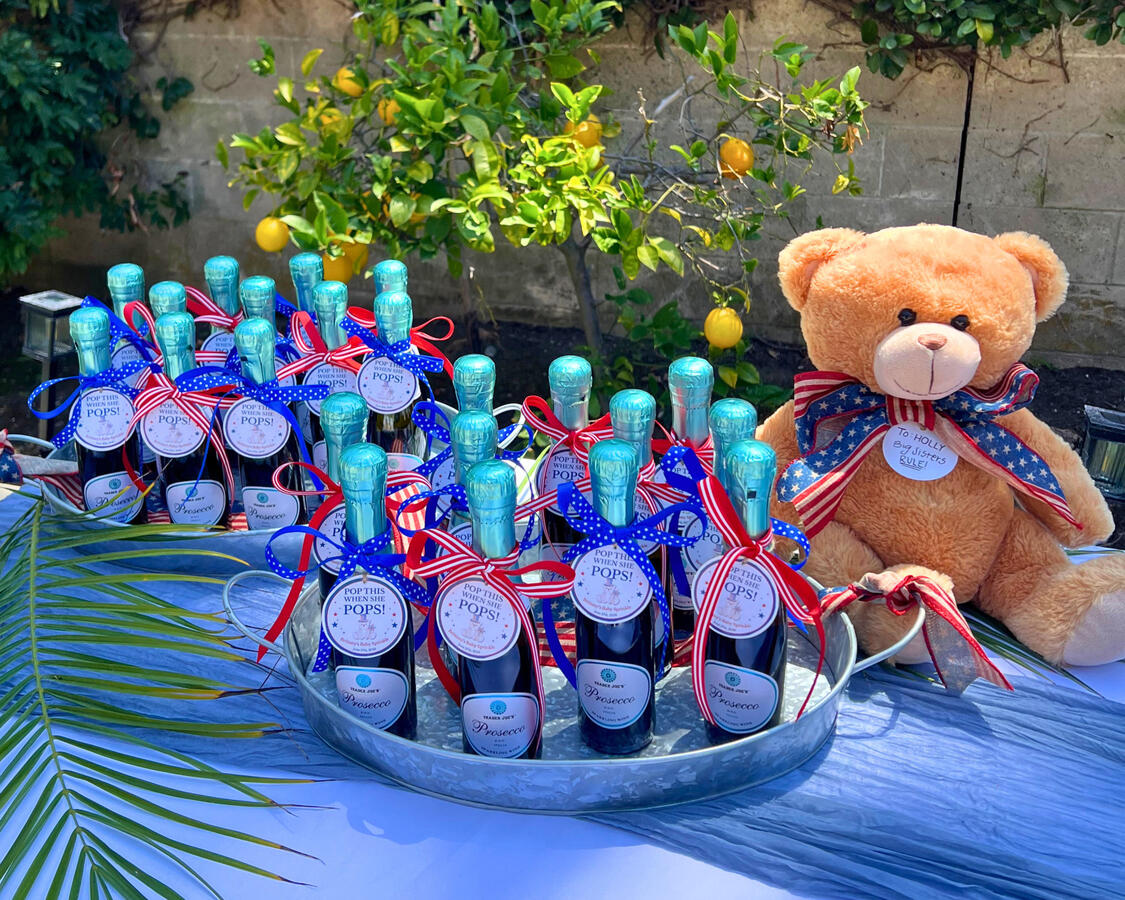 Baby Shower Party Favors — Prosecco Bottle Favors Prosecco bottle party favors with red white and blue ribbon and teddy bear for baby shower, Orange County event design